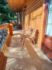 Wicker furniture stands on the terrace of a wooden house