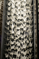 white paper cranes hanging on string