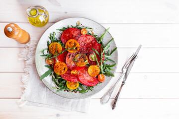 Simple Italian Salad with Tomatoes and Arugula on white wooden background, Italian Food, copy space...