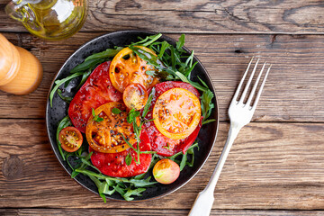 Simple Italian Salad with Tomatoes and Arugula on wooden background, Italian Food, copy space for...