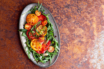 Simple Italian Salad with Tomatoes and Arugula on rusty background, Italian Food, copy space for...