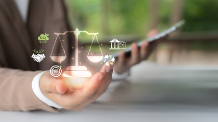 Businesswoman using mobile with legal scale icon and ESG elements like carbon reduction, recycling,...
