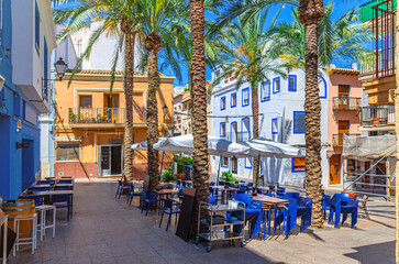 Old town Calpe city historic centre with street restaurant outdoor cafe on small square Plaza Espana, typical houses colorful traditional buildings, province of Alicante, Valencian Community, Spain