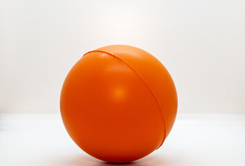 Orange anti-stress ball isolated on white background.