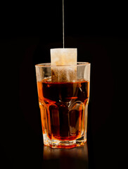 English breakfast black tea, closeup on tea bag isolated on black background
