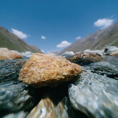 Mountain river over boulders, shadow play from fast-moving clouds