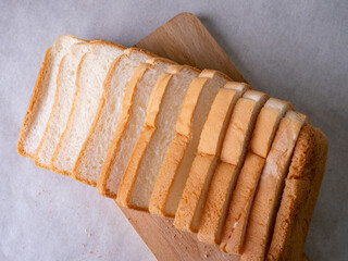 Toasted white bread loaf sliced on white background.