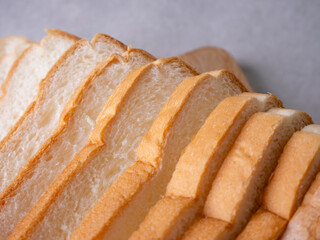 Toasted white bread loaf sliced on white background.