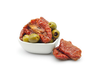 Sun dried tomatoes with green olives in oil in ceramic bowl isolated on white background....
