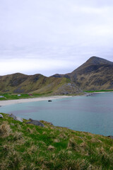 Beautiful Norwegian beach with blue water and mountains  