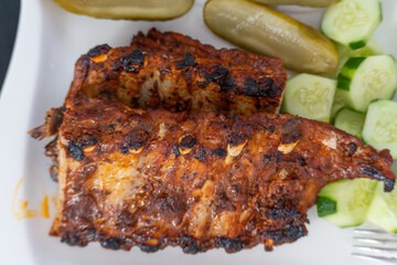 Grilled Ribs Close-Up. Juicy, grilled pork ribs with a spicy, caramelized marinade and visible...