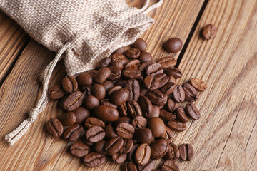 Coffee beans with miniature burlap bags on wooden table