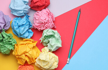 Colored balls of crumpled paper and paper sheet with pencil. Lack of ideas, stress, depression,...