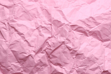 Crumpled pink paper background texture close up