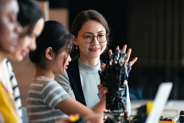 STEM Education Class With Teacher Guiding Diverse Students to Code and Build Robotic Arm Using Computers in Hands-On Engineering Activity