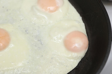 Eggs are fried in a frying pan. Cooking breakfast