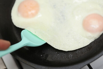 Eggs are fried in a frying pan. Cooking breakfast