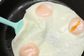 Eggs are fried in a frying pan. Cooking breakfast