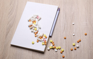 Blank medical journal or notebook with white cover and medicines on table. Mockup for design