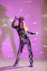 Mirror dancer performing in a purple studio with reflective outfit