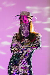 Mirror dancer posing with arms crossed on purple background