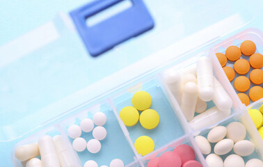 Calendar and Plastic divider box with pills on blue background