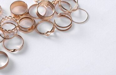 Many Gold rings of different shapes on a white background. Jewelry store, beauty concept