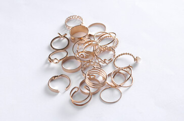 Many Gold rings of different shapes on a white background. Jewelry store, beauty concept