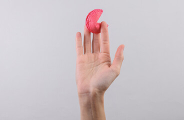 Fortune cookie in hand on gray background