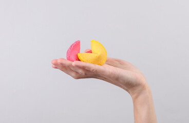 Fortune cookies in hand on gray background