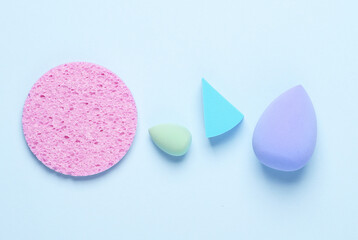 Make-up sponges, cosmetic beauty blenders on blue background. Top view. Flat lay