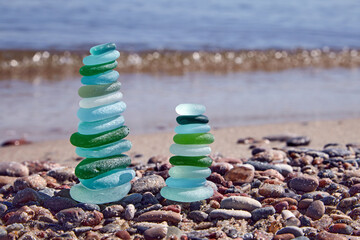 pyramids of balancing glass stones on the seashore.
