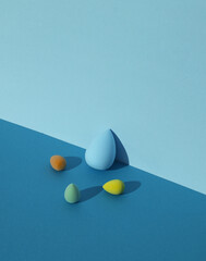 Makeup sponge blenders on a blue background with shadow. Beauty concept. Creative layout, minimalism