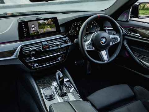 Novosibirsk, Russia -  July 10, 2024: black  BMW 5-series,    car Interior - steering wheel, shift lever and dashboard, climate control, speedometer, display