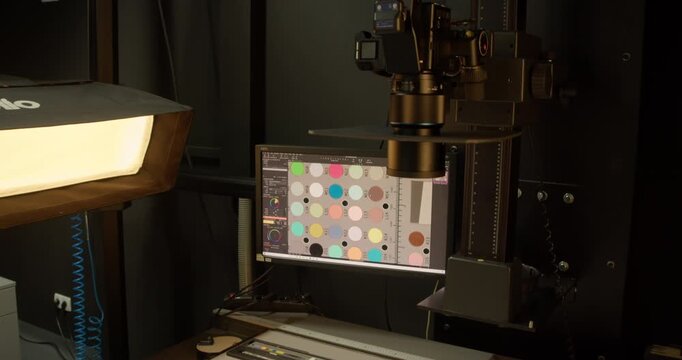 Professional digitization setup with a medium format camera system, color calibration charts, and monitor displaying color control software.