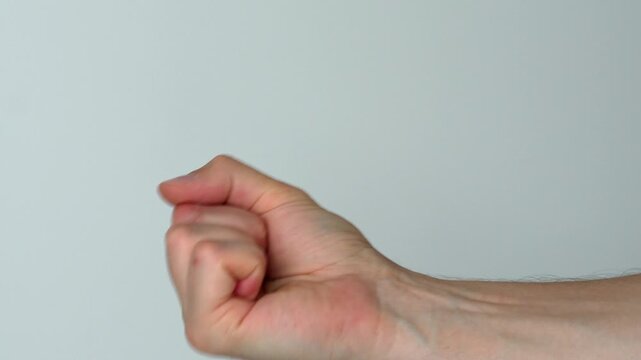 abuse and conflict.
Aggressive behavior of a guy on a white background.
A man shows a fist threatening someone