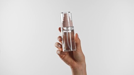 Hand Holding Transparent Cosmetic Bottle for Skincare Product Display - Powered by Adobe