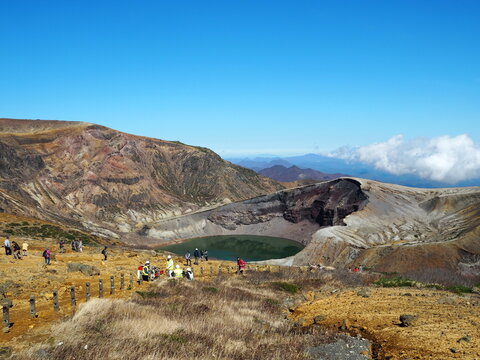 Tourists walking along the hiking trail towards Okama Crater Lake on Mount Zao, Japan.