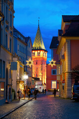 Mangturm tower in Lindau at Lake Constance, colorfully lit in festive evening mood.