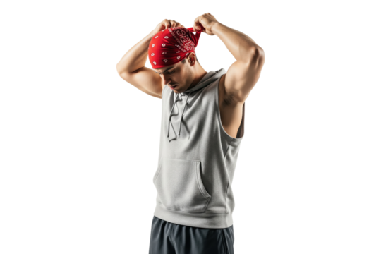 Focused young man in athletic wear tying a red bandana around his head - Powered by Adobe