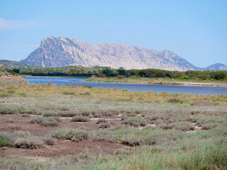 Scenic view of a mountainous landscape with a lake in the foreground in San Teodoro, Sardinia, Italy
