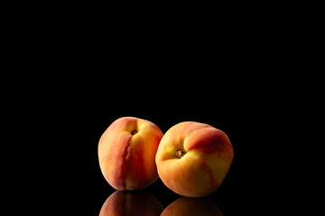 Juicy peaches isolated on black background, close-up.