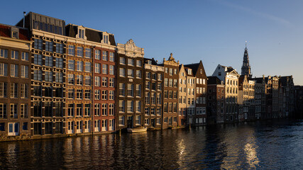 Sunset panorama of Amsterdam, including canal houses with the Oude Kerk tower