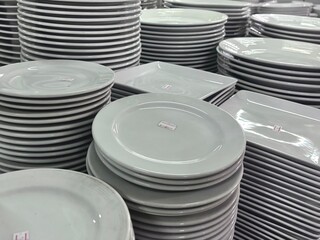 stack of plates. An expansive collection of various white ceramic dishes, including plates, bowls,...