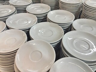 An expansive collection of various white ceramic dishes, including plates, bowls, and square...