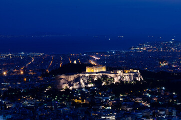 Fototapeta premium Evening view of The Parthenon and Acropolis in Athens Greece at 'Blue Hour' from Lycabettus Hill in downtown Athens Greece