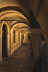 Exploring the silent arches of Poznan Market Square at night in Poland