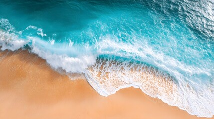 Stunning aerial view of turquoise waves crashing on a golden beach.