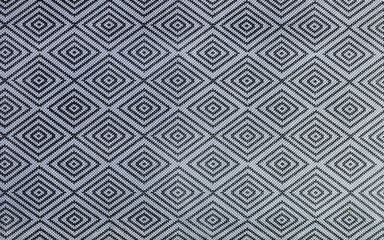 A repeating geometric diamond pattern, showcasing high-contrast black and white lines, creating an optical effect