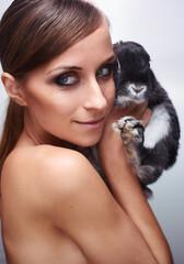 Close-Up of Smiling Woman Holding a Cute Black and White Rabbit